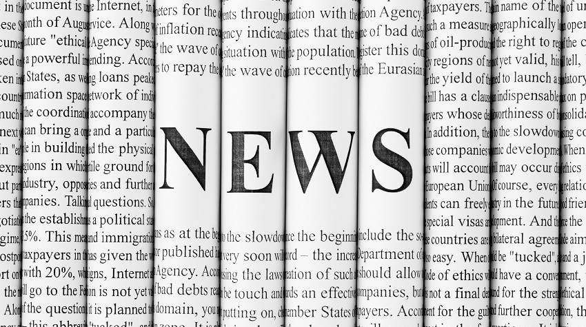 Spines of folded newspapers lined up in a row with the word "news" written in black text on a white background in the center.