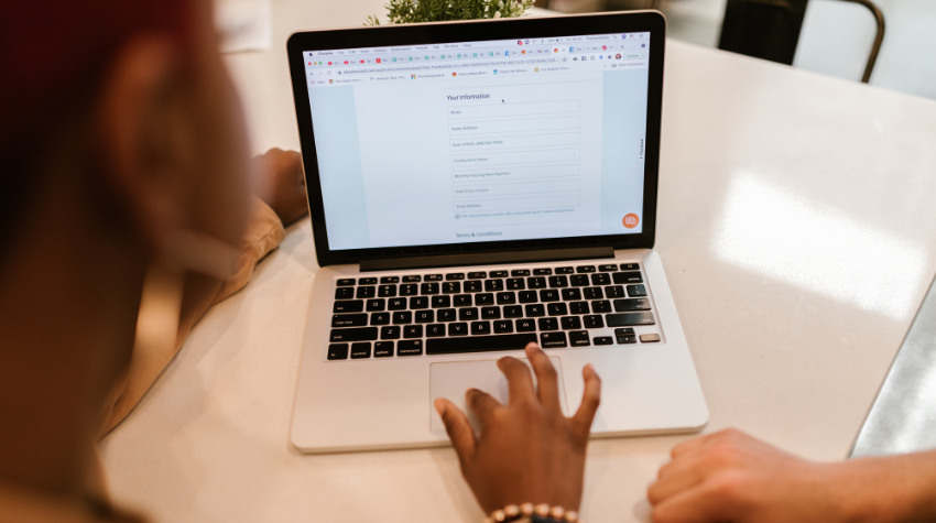 Two people sit next to each other and take an online survey.