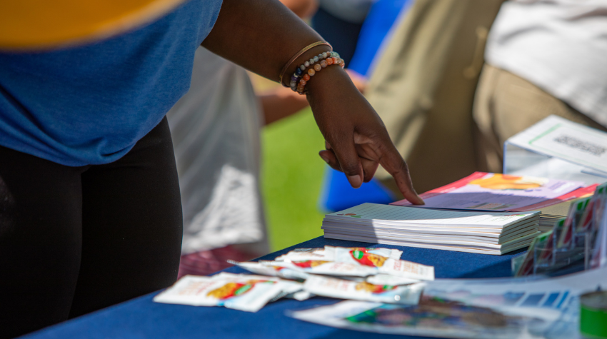 Close up of a woman's hand pointing to a table of resources.