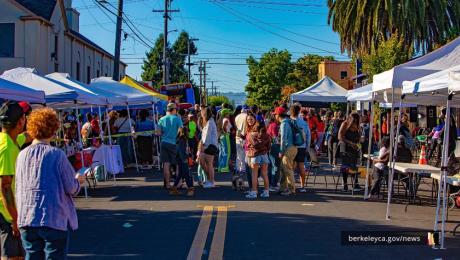 People walk the streets at event with colorful pop tents 