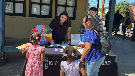 A family visits the Rent Board table at a BUSD event.